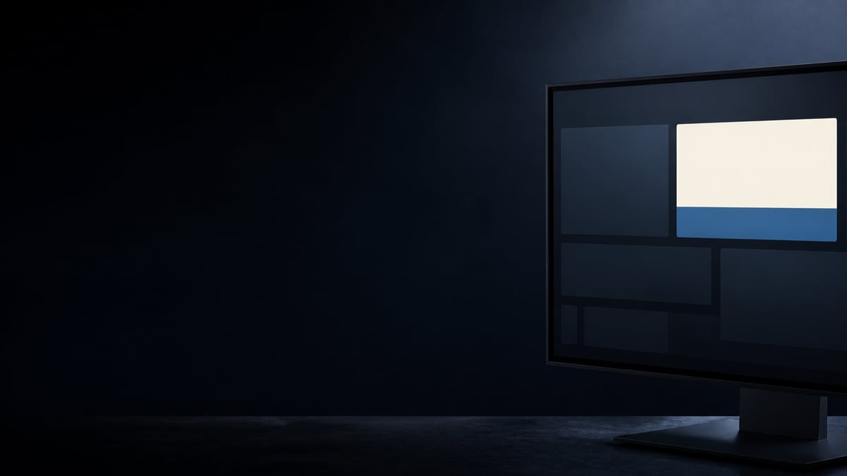 Monitor in einem dunklen Raum, auf dem Bildschirm hebt sich eine helle cremefarbene Fläche über einem blauen Band ab